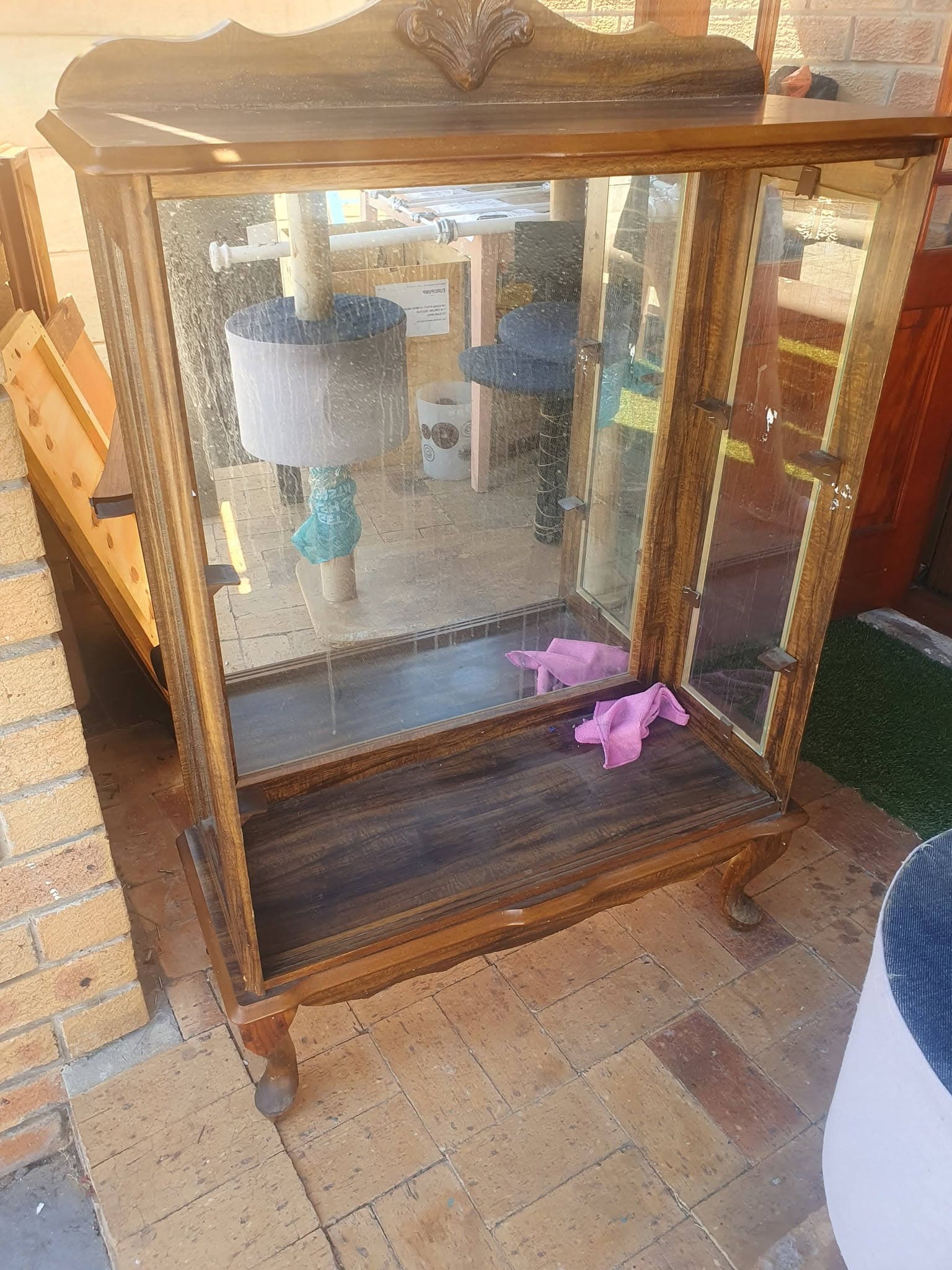 Statement bookcase before restoration, shown as a glazed wooden cabinet